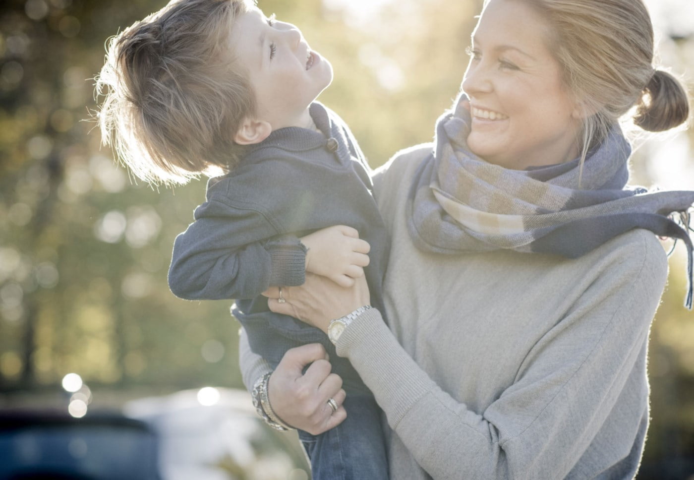 Kvinne som løftar sonen sin.