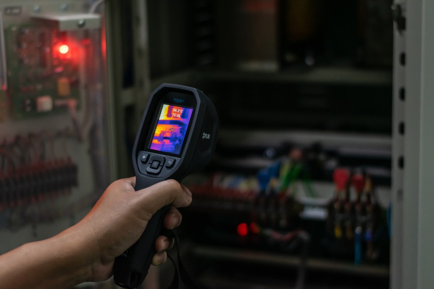 Elektrikar som brukar eit varmesøkande kamera for å finne varme punkt i eit el-anlegg.