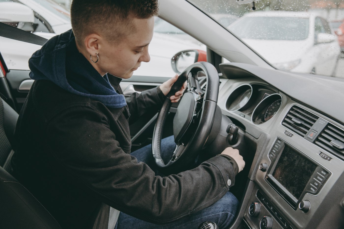Fokusert person vrir om nøkkelen for å starte bilen og førebur seg på ein sikker køyretur.