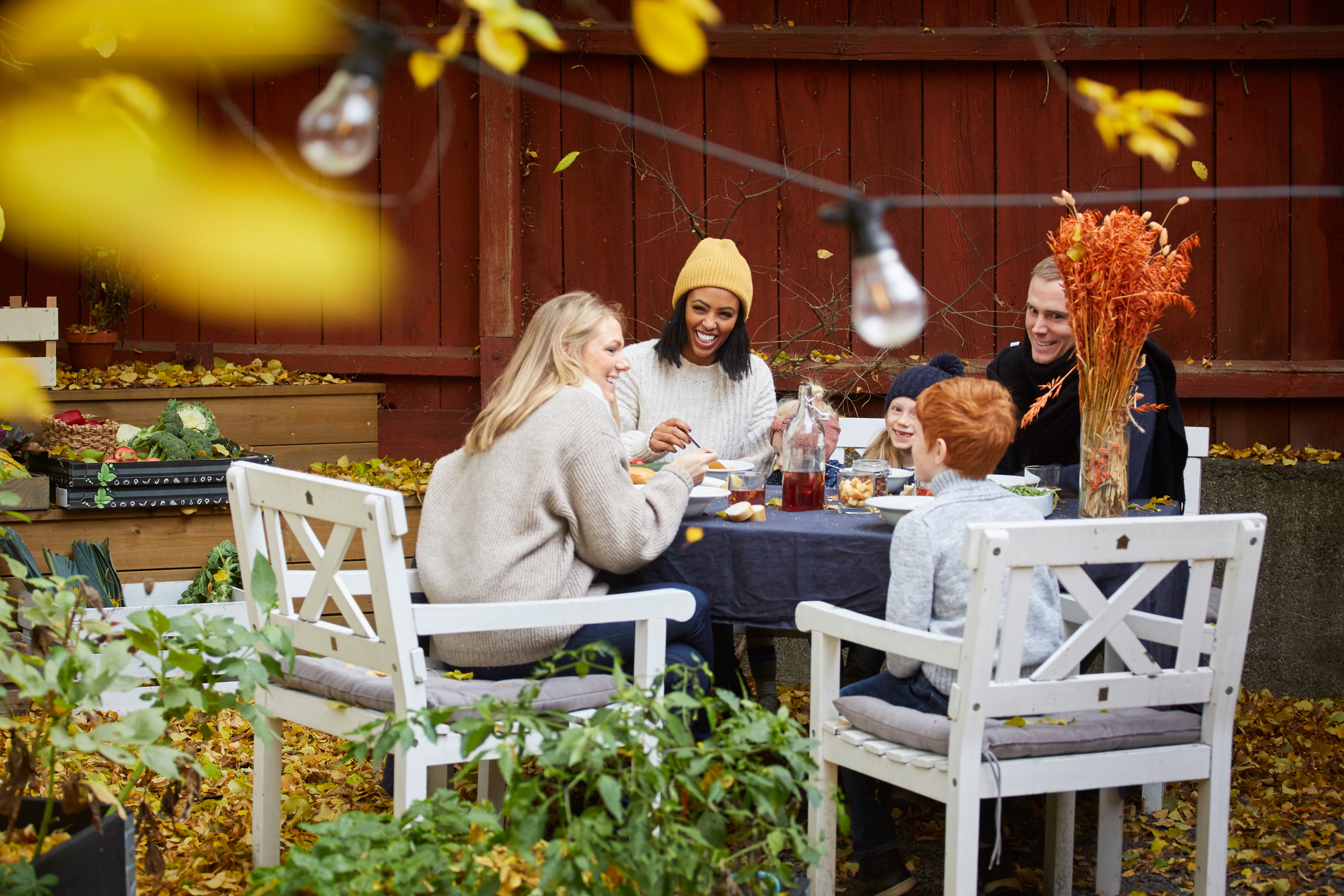 Familie som sit utandørs og et middag.