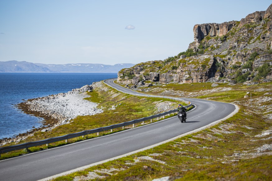 Motorsyklist køyrer langs veg ved havet